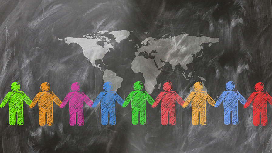 A visual representation of global unity and collaboration, showing stylized people in various colors holding hands beneath a world map on a textured dark surface.